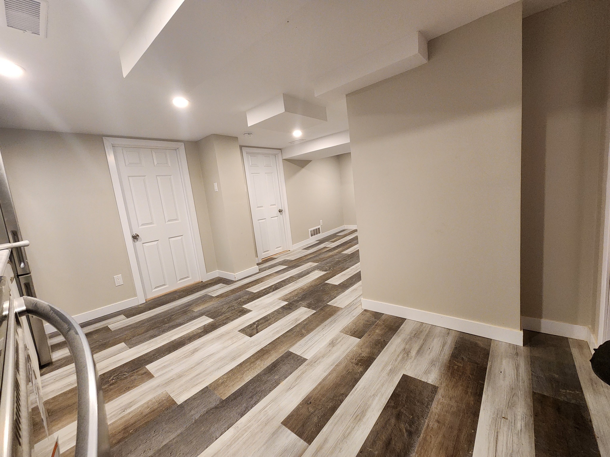 A newly built wooden deck with black railings.